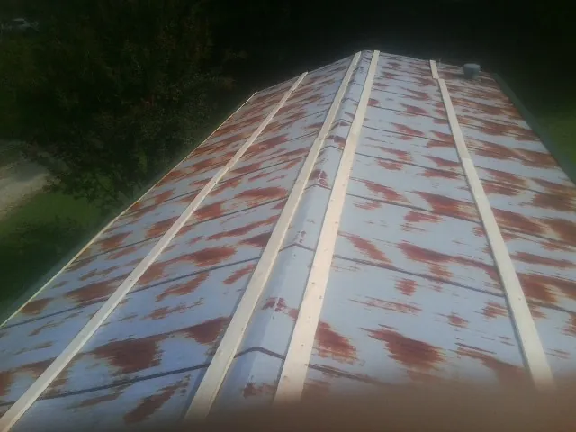 Rusted metal roof panels with new wood purlins before replacement — Storm Damage Roof Repair in Harford by Roofing Brothers
