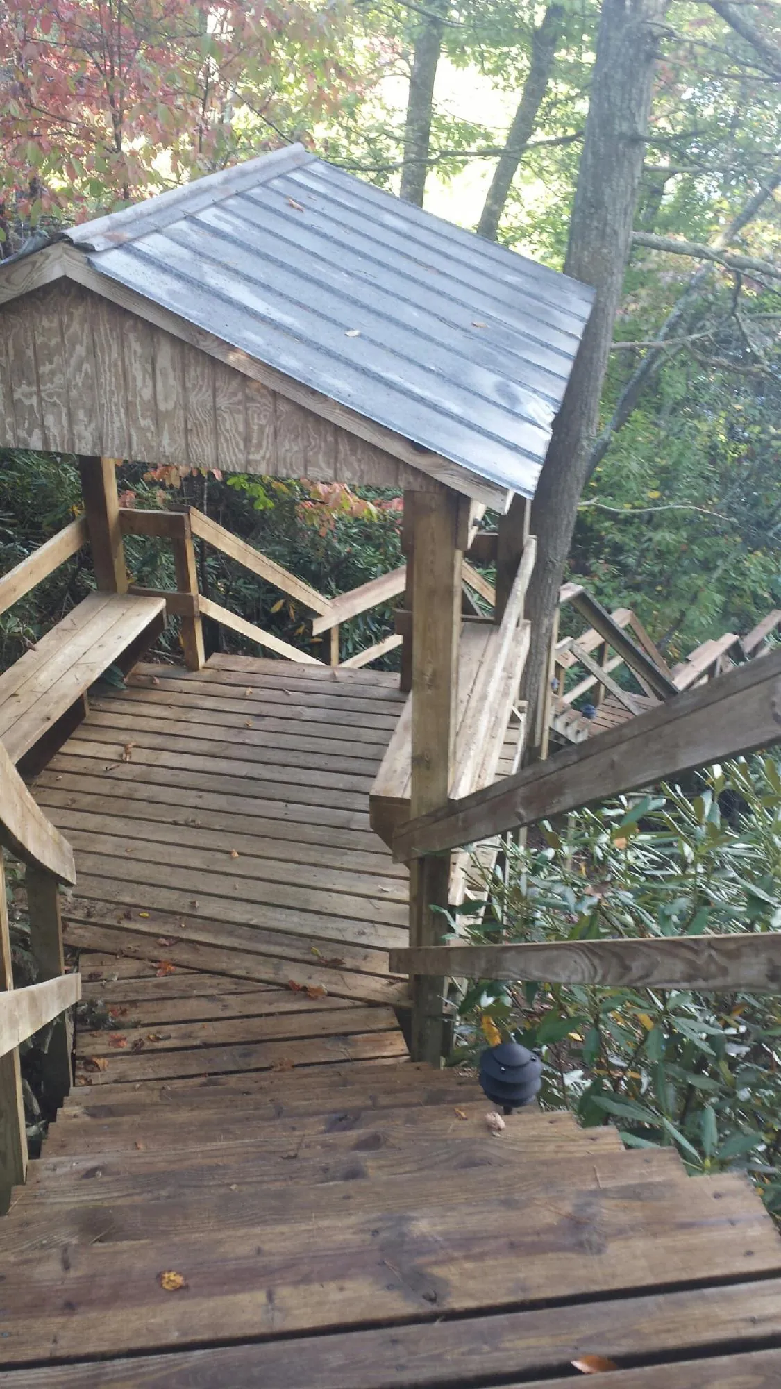 Metal roofed shelter over wooden steps on a wooded walkway — Skylight Repair & Installation work by our crew in Harford